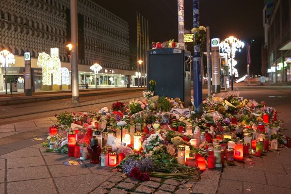Blumen und Kerzen stehen im Gedenken an die Anschlagsopfer an einer Straßenbahnhaltestelle in Magdeburg. - © Heiko Rebsch/dpa