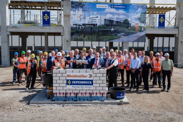 André Sombecki (Finanzvorstand Weidmüller) (von links), Volker Bibelhausen (Technologievorstand und Vorstandssprecher von Weidmüller), Dr. Sebastian Durst (Vorstand Operations Weidmüller) und Dr. Axel Lehmann (Landrat Kreis Lippe) betonieren die Zeitkapsel ein. - © Weidmüller