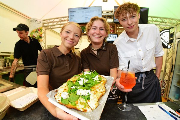Marianne Wiens (von links), Romy Altekrüger und Bent Rethemeier von "Tiny pizza" servieren frisch gebackene Pizza. - © Nicole Ellerbrake