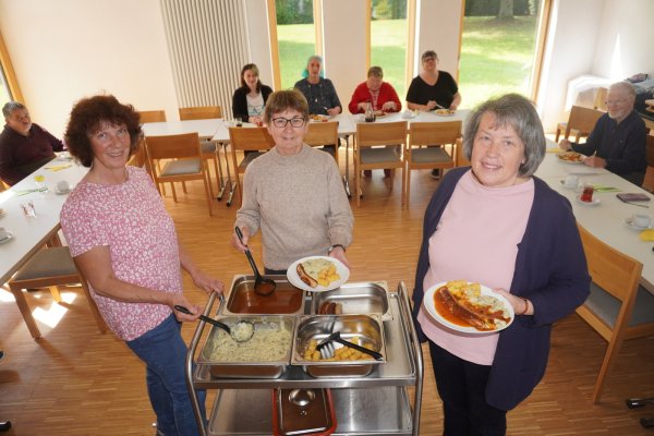 Susanne Koch (von links), Karola Durgeloh und Claudia richten das Essen auf den Tellern an. Manuela Todt-Reker (hinten, 2. von links) und Gudrun Tauer (rechts daneben) haben sich beim Mittagstisch kennengelernt. Zwischen ihnen ist eine Freundschaft entstanden. - © Michaela Weiße