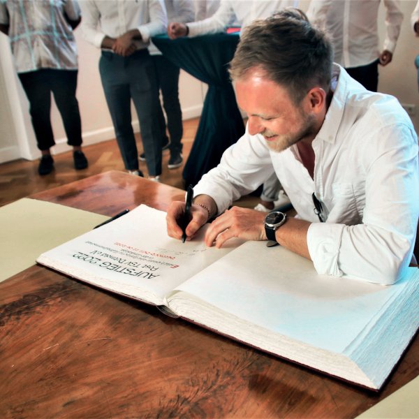 Alex Felker und die Fußballer des Post TSV-Detmold unterschreiben im Goldenen Buch. - © Stadt Detmold