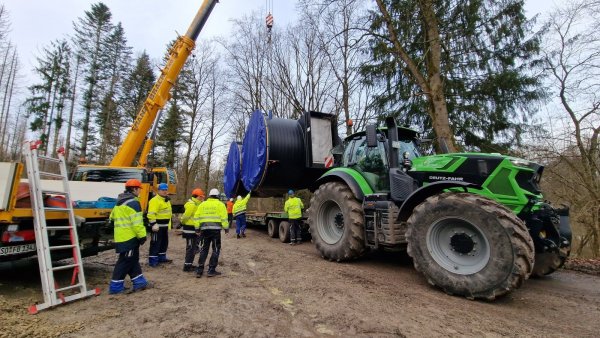 Die Schieberkammer des neuen Trinkwasserhochbehälters in Lüerdissen wird per Kran direkt neben den Försterteichen auf einen Traktor umgeladen, der ihn den Berg hochziehen wird. - © Nadine Uphoff