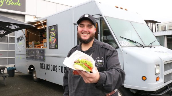 Timo Hooge steht mit dem "Smash Burger" vor seinem Foodtruck von "TMO's Catering". - © Alexandra Schaller