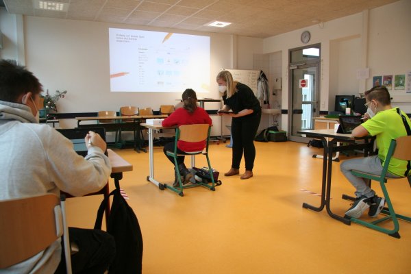 Kane Coles (links) und Diego Banosgarcia probieren sich im Umgang mit den neuen Tablets. Währenddessen erklärt Klassenlehrerin Kathrin Münstermann ihrer Schülerin Xenia Cittel einige Funktionen etwas genauer. Die Geräte sollen nicht nur das Homeschooling, sondern bald auch den Präsenzunterricht bereichern. - © Heike Delker