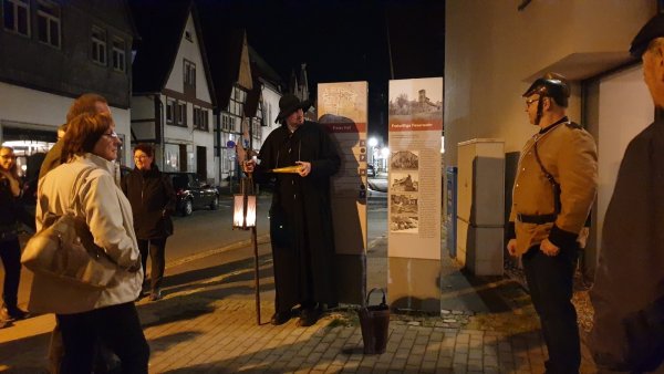 Der Nachtwächter steht mit dem Feuerwehrchef in historischer Kleidung am ehemaligen Standort des ersten Spritzenhauses der Freiwilligen Feuerwehr Lemgo. - © Nadine Uphoff