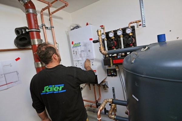 Ein Monteur nimmt die nötigen Einstellungen nach dem Einbau einer Wärmepumpe vor: Im Februar gibt es ein neues Förderprogramm für Hauseigentümer. - © picture alliance / SVEN SIMON