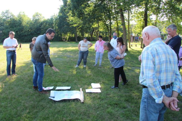 Manuel Bröker (Fachbereich Bauen, Planen, Umwelt) erläutert den Anwohnern des Spielplatzes Schlesierstraße anhand von Plänen, wie der Bolzplatz aufgewertet und das Gelände insgesamt barrierefrei gestaltet werden soll. Links Bürgermeister Dr. Andreas J. Wulf. - © Dieter Asbrock