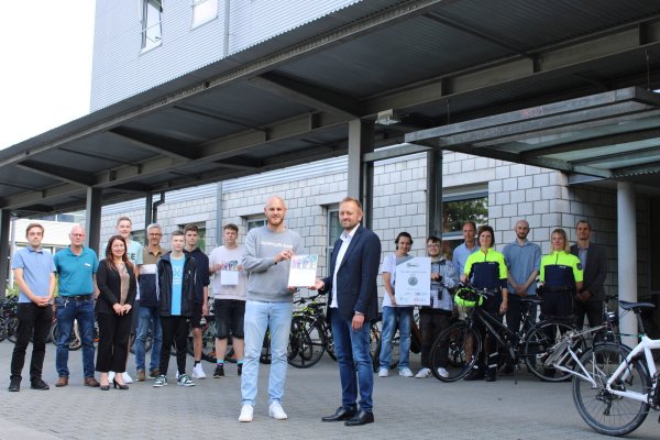 Freuen sich über das Zertifikat "Fahrradfreundliche Schule": (von links) Nils Kümmel (Bundesfreiwilligendienstler beim Kreis Lippe und Organisator des Projekts), Gerhard Reineke (Radverkehrsbeauftragter der Stadt Lemgo), Manuela Kupsch (Leiterin des Eigenbetriebs Schulen des Kreises Lippe), Jannis Teubner (Schüler), Bastian Kochsiek (Lehrer), Timo Vornberger, Tjorven Klein, Paul Mertinat (alle drei Schüler), Dennis Hetmann (Mobilitätsmanager des Kreises Lippe), Bernd Hendig (Schulleiter), Jamaal Tariq, Karl Dengel (beide Schüler), Thorsten Niemeier (Lehrer), Heijenga Kerstin (Polizei), Christian Bange (stellvertretender Radverkehrsbeauftragter des Kreises Lippe), Tanja Menze (Polizei) und Thorsten Quest (stellvertrender Schulleiter). - © Chiara Wibbeke