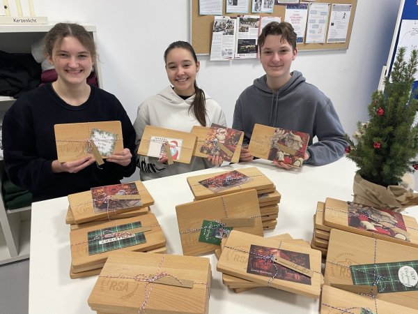 Schülersprecher Hanna Balzer, Bianca Benchea und Younes Belhadj (von links) freuen sich, dass sie jedem Lehrer der Augustdorfer Realschule zu Weihnachten ein Frühstückbrettchen mit dem neuen Logo der Schule überreichen können. - © Edith Kemeny