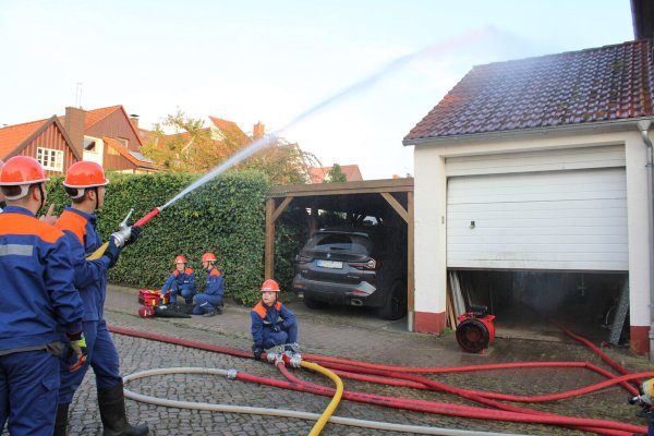 Im hohen Bogen löscht die Jugendfeuerwehr Blomberg den simulierten Garagenbrand und versorgt die "verletzte" Person. - © Chiara Wibbeke