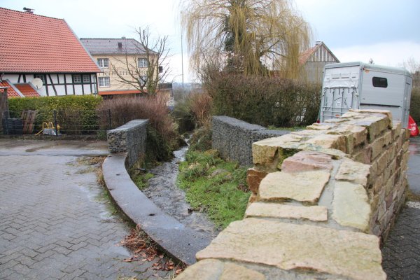 Wo einst eine Brücke über den Holzhauser Bach führte, verhindern jetzt Gabionen, dass man ins Wasser fällt. In diesem Bereich kann sich der SPD-Ortsverein einen Rastplatz für (Rad-)Wanderer vorstellen, der auch gleichzeitig als Dorftreffpunkt dienen soll. - © Dieter Asbrock