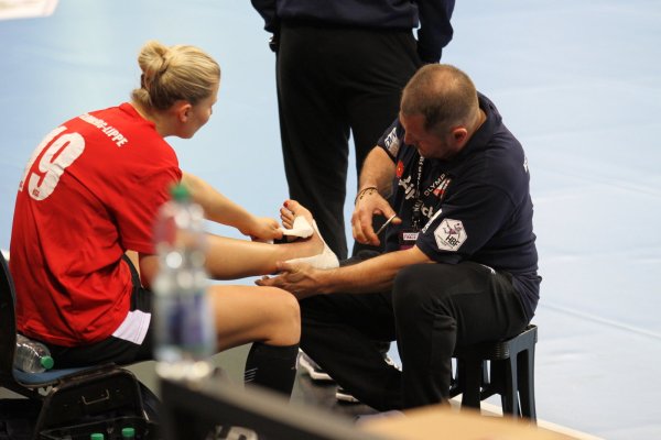 Sekunden vor dem Abschlusstraining nimmt Physio Sergej Gontcharov der Blomberger Abwehrchefin Kamila Kordovska den Verband vom lädierten linken Knöchel ab. Gut möglich, dass die Tschechin beim Final Four in Stuttgart zum Einsatz kommt. - © Dietmar Welle