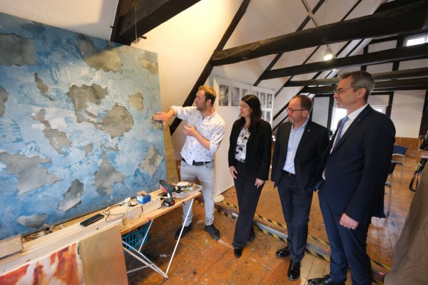 Im Künstlerhaus zeigt Michael Eppler Kunstreferentin Dr. Mayarí Granados, Landesverbands-Vorsteher Jörg Düning-gast und Schieder-Schwalenbergs Bürgermeister Jörg Bierwirth eines seiner "Schaumbilder". - © Sven Koch