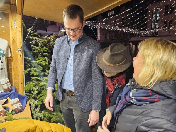 Die Wette gilt: Bürgermeister Matthias Kalkreuter schaut auf die Waage, die auch Helmut Behnisch (Mitte) und Martina Hannen von der FairTrade-Steuerungsgruppe kontrollieren. Wenn 925 Schokoladentafeln am FairTrade-Stand verkauft werden, wird das Stadtoberhaupt 185 Bäume pflanzen. - © Astrid Sewing