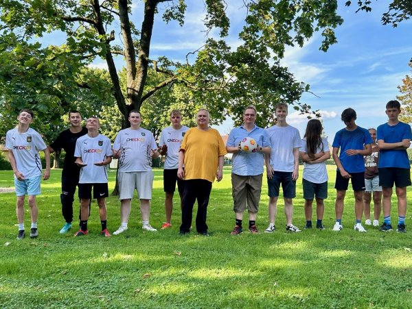 Jubiläumssieger: Die Mannschaften „RTG United“ (links) und die „No Names“ (rechts) beim Fußballturnier in Heidenoldendorf. In der Mitte Schiedsrichter Harald Könitzer (in gelb), Dennis Maelzer (mit Ball) und Juso-Vorsitzender Gerrit Sander. - © Bildrechte: Dennis Maelzer