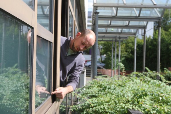 Marc Reinhardt, Hausmeister am Felix-Fechenbach-Berufskolleg, zeigt: Die Fenster sind hin. Viele lassen sich nicht mehr öffnen, Wärmedämmung ist ein Fremdwort. - © Martin Hostert