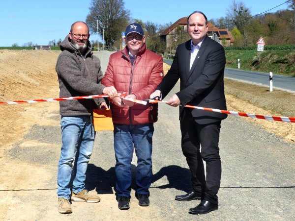 Mit dem Durchschneiden des Bandes haben Detlef Wehrmann (von links), Fachbereichsleiter für Bauen und Stadtentwicklung, Ortsvorsteher Lothar Vogt und Bürgermeister Christoph Dolle den Bürgerradweg freigegeben. - © Rudi Rudolph