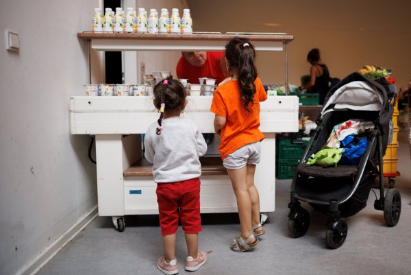 ARCHIV - 03.07.2023, Berlin: Ein Mitarbeiter verteilt Jogurt an zwei Kinder in der Ausgabestelle Paul-Schneider-Haus der Berliner Tafel. (zu dpa «Bundesregierung beschließt Kindergrundsicherung») Foto: Carsten Koall/dpa +++ dpa-Bildfunk +++ - © Carsten Koall
