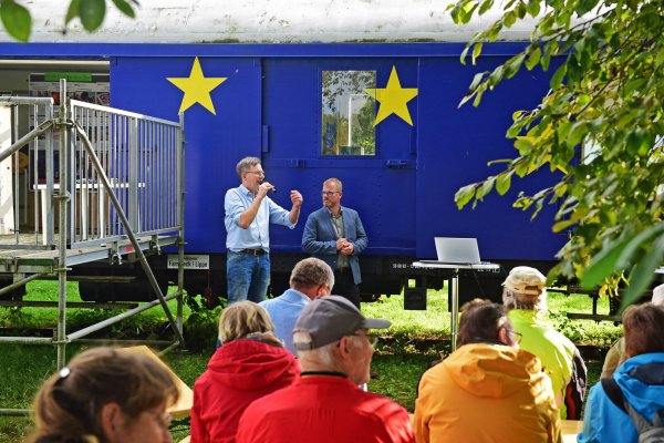 Jochen Brunsiek, Geschäftsführer des Kulturstellwerks Nordlippe (links) und Bürgermeister Friso Veldink sprechen vor Publikum über Dörentrups Nahmobilät. - © Nicole Ellerbrake