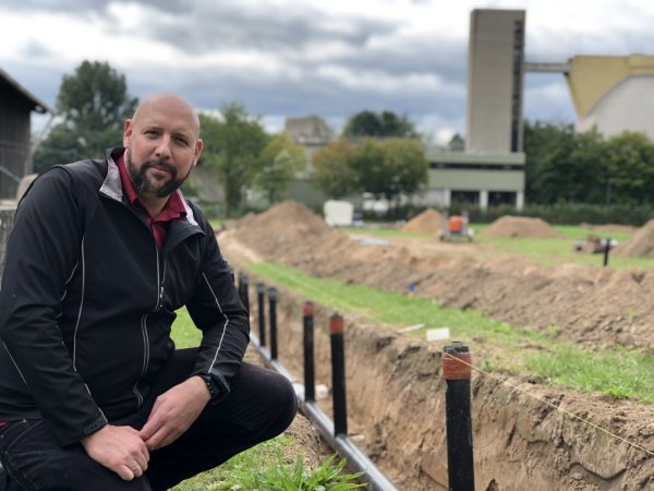 Projektleiter Daniel Steube von den Stadtwerken zeigt eine der Fernwärmeleitungen der neuen Solarthermie-Anlage am Klärwerk (rechts im Hintergrund). Auf der Fläche soll mit Hilfe der Sonnenenergie ab kommendem Jahr Energie gewonnen werden.  - © Till Brand