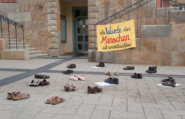 „Die Würde des Menschen ist unantastbar“ steht auf einem Plakat, das an der Rathaustreppe hängt. - © walter meutzner