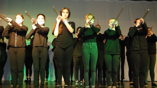 Wirkt bedrohlich, wie die Performance-Künstlerinnen der Jahrgangsstufe 7 mit ihren Bambusstangen ins Publikum zielen, ist aber durchaus harmlos. Sie zeigen pantomimisch unterschiedliche Facetten von "Unterwegs sein". - © Hajo Gärtner