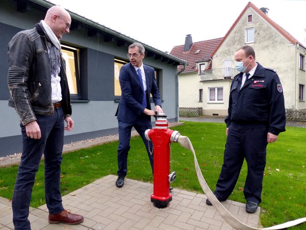 Mit Inbetriebnahme des Hydranten gilt das Feuerwehrgerätehaus offiziell als übergeben. Wilhelm Luft vom Architekturbüro Schmidt (links), Bürgermeister Jörg Bierwirth und Marc Tegeler, Einheitsführer Wöbbel, freuen sich. - © Rudi Rudolf
