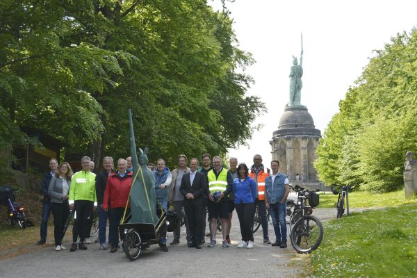 Empfingen das XXL-Modell des „Kantigen Hermanns" am Original des Denkmals in Detmold: Dörte Pieper (Stadt Detmold, 2. von links), Kurt Kalkreuter (Stellvertretend für Landrat Dr. Axel Lehmann, 6. von links), Günter Weigel (Geschäftsführer der LTM, 8. von rechts), Jörg Düning-Gast (Verbandsvorsteher des Landesverbands Lippe, 7. von rechts) mit der Delegation aus Hövelhof, die begleitet wird von Hubert Böddeker (Vorsitzender des Verkehrsvereins Hövelhof, 3. von links), Hövelhofs Bürgermeister Michael Berens (4. von links), Thomas Westhof (Wirtschaftsförderung und Marketing Hövelhof, 6. von rechts) und Anja Veith (Geschäftsführerin Touristikzentrale Paderborner Land, 3. von rechts).  - © LTM GmbH