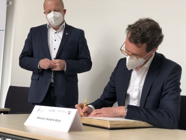Für seinen Eintrag ins Goldenen Buch nimmt sich der nordrhein-westfälische Verkehrsminister Hendrik Wüst Zeit. Er wünsche der Gemeinde Kalletal auf „ihrem (Fuß-)weg Richtung Zukunft alles Gute". Bürgermeister Mario Hecker nimmt’s zufrieden zur Kenntnis.  - © Till Brand