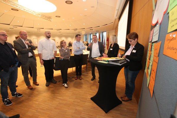 Landrat Dr. Axel Lehmann (3.von rechts) diskutiert mit (von rechts) Sabine Beine (Verwaltungsvorständin Kreis Lippe), Daniela Brenker (Leiterin Fachbereich Ordnung, Kreis Lippe), Prof. Jürgen Jasperneite (Fraunhofer IOSB-INA), Sandra Stövesand (Familienbetreuung Kreis Lippe), Thomas Frank (Diakonie, Lippische
Landeskirche), Stefan Susat (Vorstand Jobcenter Lippe) und Dirk Menzel (Leiter Fachdienst Bildung, Kreis Lippe) über einzelne Aspekte eines Welcome-Centers. - © Kreis Lippe