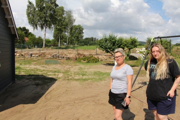 Eva Topor (links) und ihre Tochter Klaudia Pooch in ihrem Garten. Vom Feld im Hintergrund kamen im Mai und Juni die Wasser- und Schlammmassen den Garten und die Straße hinuntergeflossen. - © Archivfoto: Freya Köhring