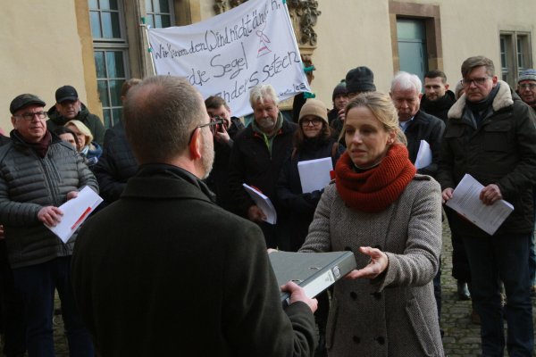 Dr. Stella Junger-Schwenner (Grüne), stellvertretende Bürgermeisterin von Horn-Bad Meinberg, übergibt Landesverbandsvorsteher Jörg Düning-Gast eine Petition zum sofortigen Stopp der Planungen von Windenergieanlagegen im Teutoburger Wald. - © Martin Hostert