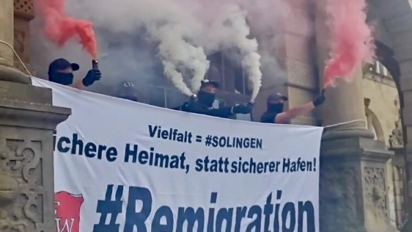 Die rechte Gruppe "Freischar Westfalen" inszeniert sich vermummt und mit Bengalos vor dem Bielefelder Rathaus. - © Screenshot: Telegram / Freischar Westfalen