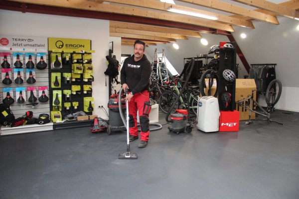 Holger Ehm versucht, die Reste des Feuerlöschpulvers wegzusaugen. Seinen Fahrradladen haben die Einbrecher ziemlich leergeräumt. - © Nadine Uphoff