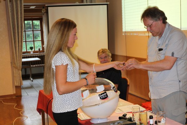 Im Matorfer Gasthaus „Hartmann" zog Vivienne Ajukassov die Pokallose, die Lemgos Fußball-Chef Bernhard Brandt unter den Augen von Werner Fritzensmeier entgegennahm.  - © Dietmar Welle