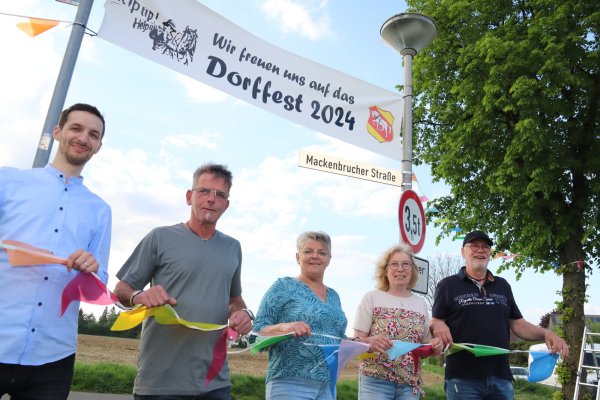 Ausschließlich ehrenamtlich wird das Dorffest vorbereitet. Zum Organisationsteam gehören Dean Rempel (v. l.), Matthias Fortkord, Gabi Budde, Evelin und Bernd Rößer. Mit bunten Wimpeln schmücken sie den Eingang zum Veranstaltungsgelände. - © Knut Dinter