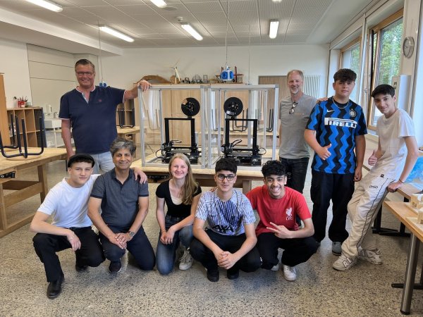 Die ersten Drucker sind schon passend im Gehäuse: Zweiter von links: Thomas Mahlmann (zdi-Zentrum Lippe.Mint, Zweiter von links), Morteza Atrsaie (Heinrich-Drake-Realschule, Dritter von links), Oliver Uthoff (Weidmüller, Dritter von rechts) mit den Schülerinnen und Schülern des Technikkurses. - © Lippe Bildung