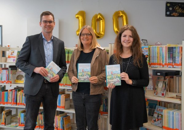 Carolin Jenkner-Kruel (Mitte) überreicht Bürgermeister Matthias Kalkreuter und Leiterin der Stadtbücherei Lage, Eva-Maria Allert, Exemplare ihres neuen Kinderbuches. - © Stadt Lage
