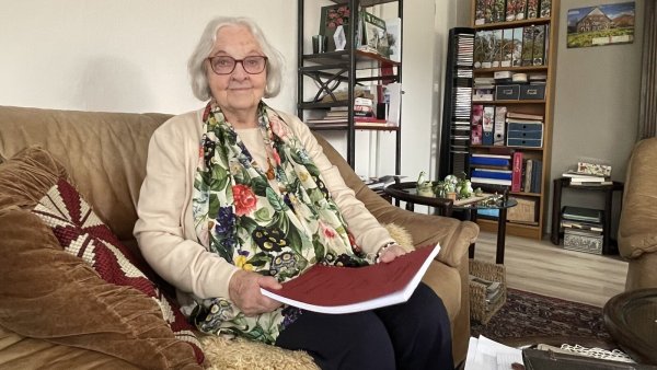 Adelgunde Sander sitzt in ihrem Wohnzimmer in Laßbruch, auf dem Schoß die rote Kladde mit Erinnerungen, die ihre Mutter vor 30 Jahren niederschrieb. - © Bildrechte: Adelgunde Seidel