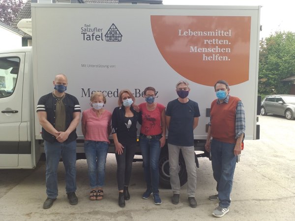 Dursum, Margitta Albrecht-Nestmann, Helena Funke, Birgit Kuhlmann, Michael Gumpert und Thomas Krauspe (von links) stehen mit Masken am Wagen der Tafel. Foto: Tafel Bad Salzuflen - © Tafel Bad Salzuflen