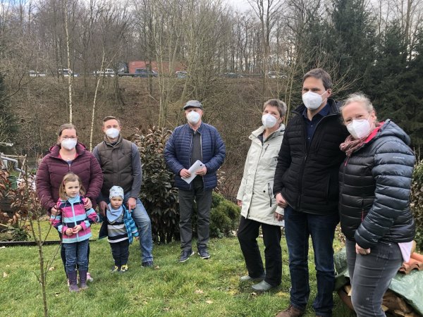 Lärmschutz an der B66 – den fordern (von links) Christine und Thomas Möllerfriedrich mit Emma und Mattheo, Ratsherr Heinz-Rainer Krüger, Anke Pethig sowie Stefan und Susanne Drauschke. Aus ihren Gärten schauen die Voßheider direkt auf den Anschluss der Südumgehung an die Blomberger Straße. Hinter den Fichten (rechts) steht die Baustellenampel, die den Verkehr einspurig über die Passadetalbrücke lotst. - © Till Brand