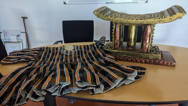 Rechts ist der Häuptlingsschemel zu sehen und links der sogenannte Fugu, ein traditionelles Kleidungsstück für besondere Anlässe. - © Mario Hecker