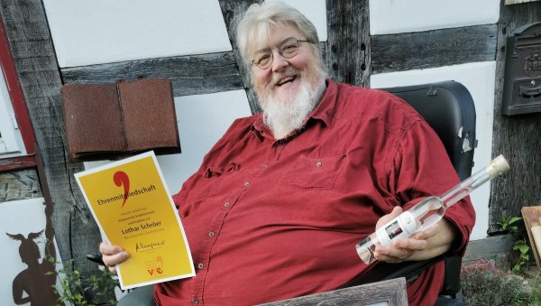 Blickt auf 20 Jahre Bühnenpräsenz zurück und wurde zum ersten und bis dato einzigen Ehrenmitglied des Verbandes der Erzählerinnen und Erzähler berufen: Der Kalletaler Erzähler Lothar Schröer, der darauf einen Schluck mit dem neuen lippischen Zwergen-Präsidenten trinken will. - © Sylvia Frevert