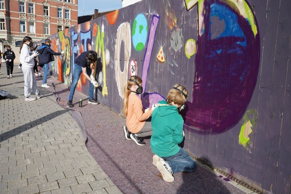 Mit Atemschutzmasken, Spraydosen und Malerrollen haben sich die jungen Kreativen am Bauzaun verewigt. - © Stadt Detmold