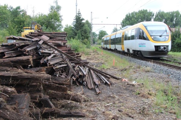 Noch fährt die Eurobahn an den fein säuberlich aufgestapelten Schienen und Schwellen vorbei, die Spezialmaschinen (hinten links) aus dem Boden geholt haben. Ab Freitag ist für zwei Monate Schluss mit Zugverkehr – die Strecke wird zwischen Detmold und Altenbeken erneuert. - © Dieter Asbrock