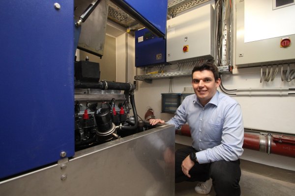 Yannic Hausmann, neuer Klimaschutzmanager der Gemeinde Extertal, mit dem Blockheizkraftwerk im Keller des Rathauses. Das erzeugt Wärme und Strom aus Gas - zwar nicht CO2-neutral, aber effizienter als viele andere Heizungen auch in Gebäuden der Gemeinde Extertal. - © Jens Rademacher