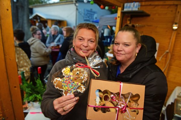 Melanie D`Andrea (links) und Jessica Szameitpreiks verkaufen die von den Schützen selbstgebackenen Kekse und Lebkuchenmännchen - © Nicole Ellerbrake