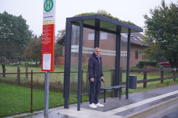 Das Dach der Bushaltestelle Ostlandstraße ist begrünt. Bürgermeister Marcus Püster wartet bei Regenwetter auf den Bus. - © Gemeinde Schlangen