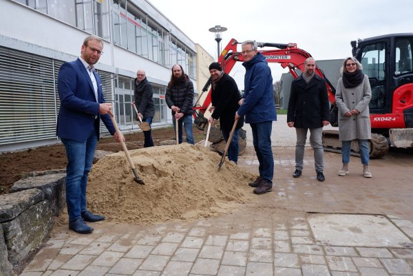 Bürgermeister Borris Ortmeier (von links), Andreas Wilde (Vorsitzender Ausschuss für Schule, Soziales und Generationen), Henning Waltermann (stellvertretender Vorsitzender Ausschuss für Bauen, Klimaschutz und Umwelt), Christian Olschweski (Vorsitzender Ausschuss für Bauen, Umwelt und Klimaschutz), Markus Tackenberg (stellvertretender Schulleiter), Chris Hüte-Getboga (Leiter Bauen, Soziales und Ordnung) und Caroline Reil (stellvertretende Vorsitzende Ausschuss für Schule, Soziales und Generationen) beim symbolischen ersten Spatenstich. - © Lorraine Brinkmann