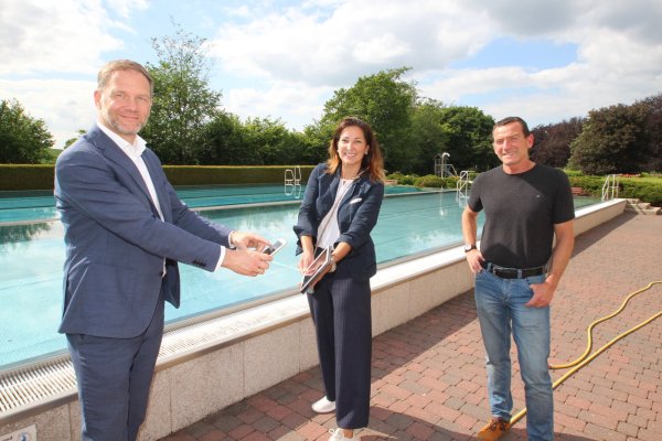 Startklar für eine Saison unter Corona-Bedingungen: das Barntruper Freibad. Bürgermeister Jürgen Schell (links) und Petra Fiedler von der Firma Inproma aus Wuppertal zeigen, wie die Adresserfassung per Handy funktionieren soll. Rechts: Schwimmmeister Hans-Dieter Meier. - © Jens Rademacher